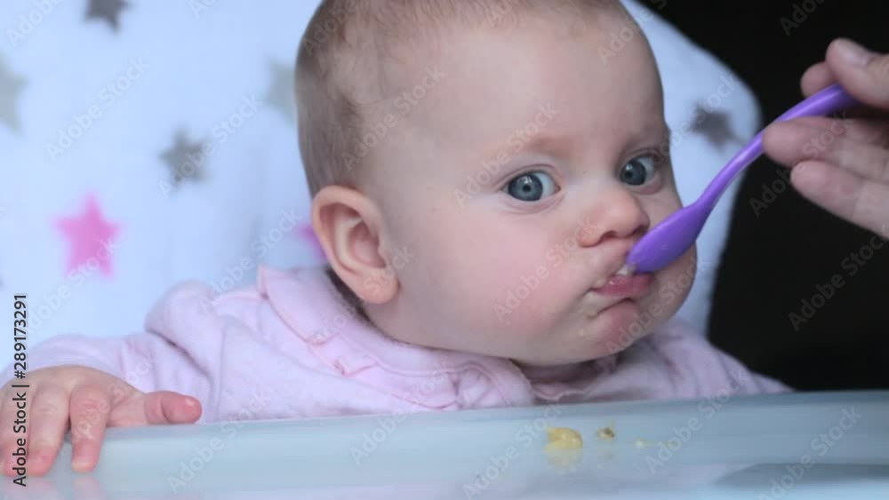 Grandmother Feeding 5 month old Beautiful Baby Girl with a Spoon, Healthy Eating Grandmother Feeding 5 month old Beautiful Baby Girl with a Spoon, Healthy Eating