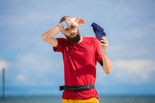 man in red shirt training by the sea 
