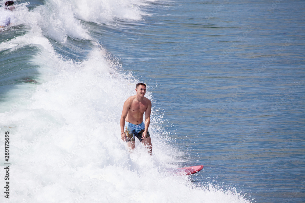 Naklejka premium surfer iding the waves at pacific beach