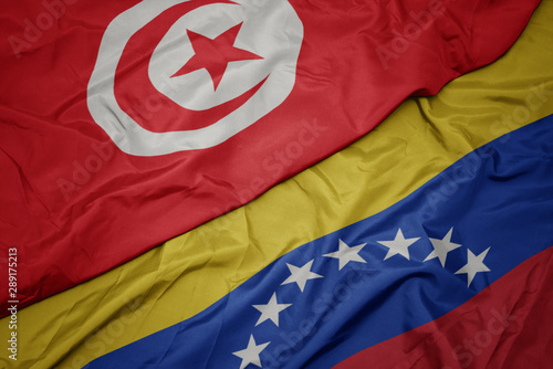 waving colorful flag of venezuela and national flag of tunisia.