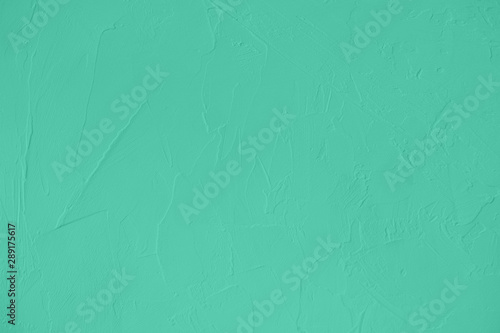 Trendy mint colored low contrast Concrete textured background with roughness and irregularities to your design or product. Color trend concept.