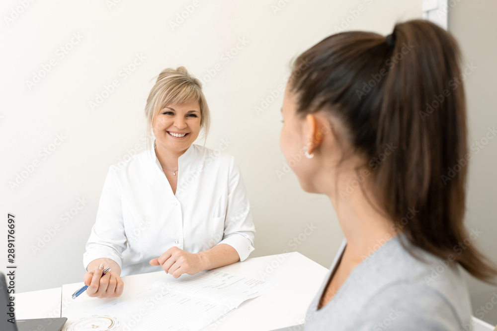 Beautiful woman gynecologist is conducting a reception with a young girl. Consultations and help gynecologist Beautiful woman gynecologist is conducting a reception with a young girl. Consultations and help gynecologist