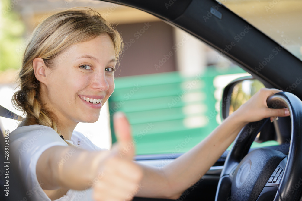 female traveler on the road holding thumbs up female traveler on the road holding thumbs up