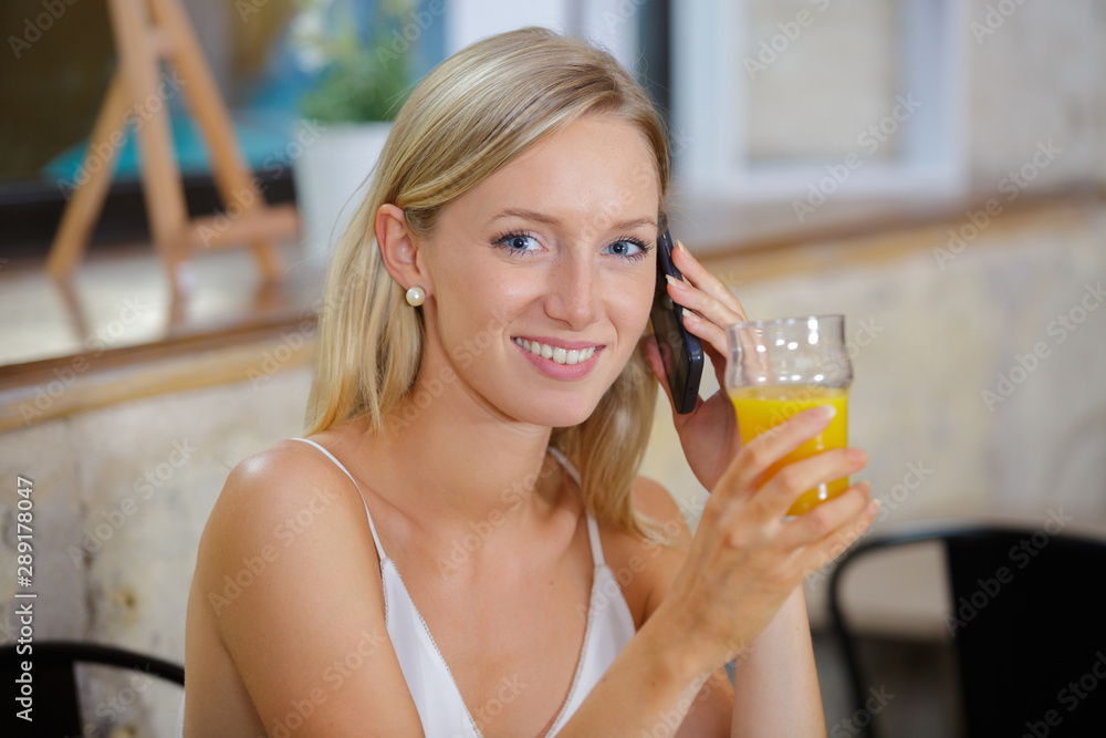 woman taking telephone call while in cafe woman taking telephone call while in cafe
