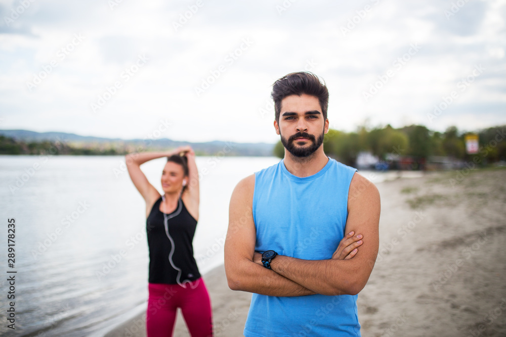 fit couple on beach exercising