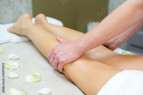 masseur massaging the backs of a womans legs