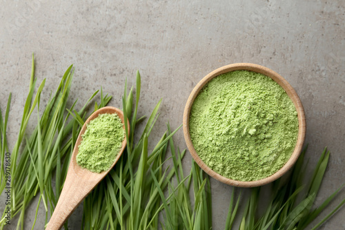 Flat lay composition with wheat grass and sprouts on grey table photo