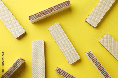 Fotografia Tasty wafer sticks on yellow background, flat lay. Sweet food