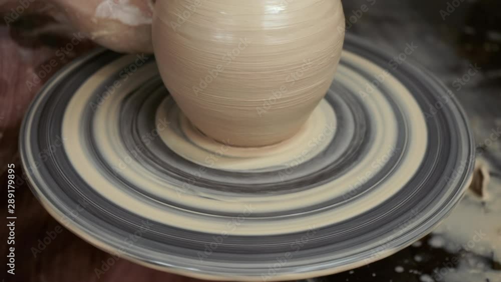 The potter makes a jug of clay. Ceramist. A man makes a vase on a potter's wheel. Hands of the master turn a piece of clay into a jug. Handwork. Pottery. Sculptor's wet hands close up. Clay dishes The potter makes a jug of clay. Ceramist. A man makes a vase on a potter's wheel. Hands of the master turn a piece of clay into a jug. Handwork. Pottery. Sculptor's wet hands close up. Clay dishes