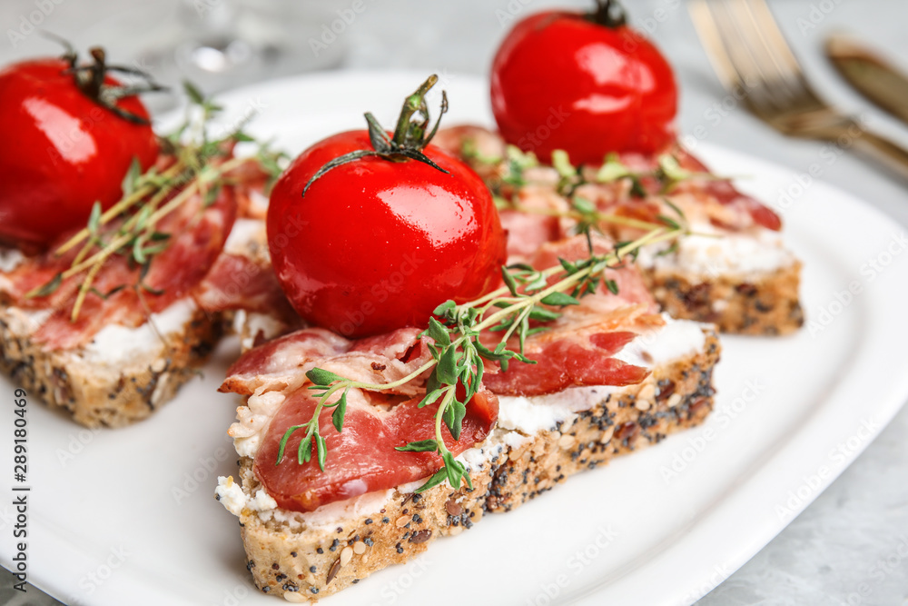 Plate of delicious bruschettas with prosciutto on grey table, closeup Plate of delicious bruschettas with prosciutto on grey table, closeup
