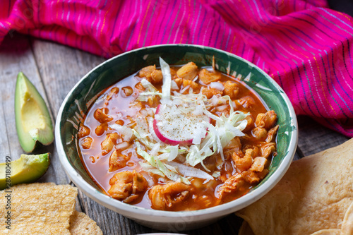 Mexican red pozole soup on wooden background photo