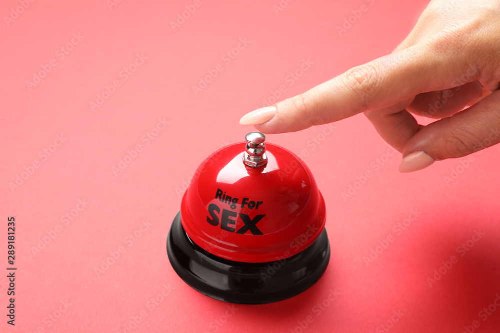 Young woman with sex bell on red background, closeup - obrazy, fototapety, plakaty 
