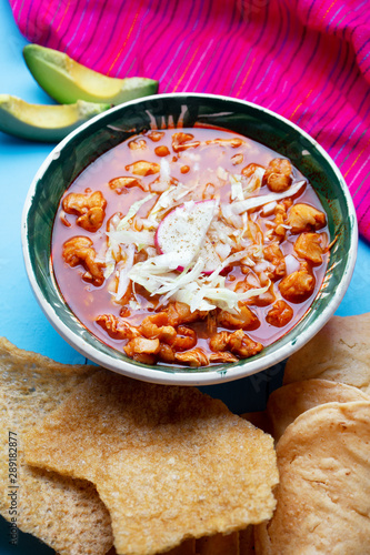 Mexican red pozole soup on blue background