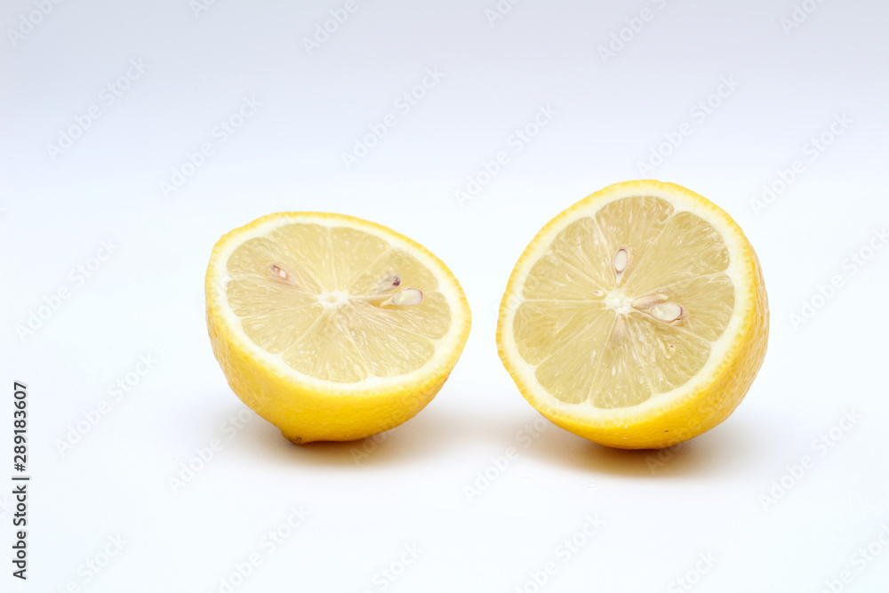 Fresh, ripe, isolated, juicy bisected lemon on a white background. Studio macro shoot
