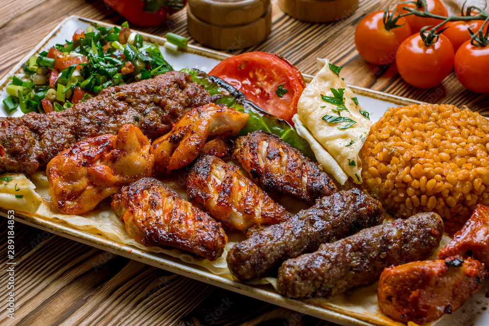 assorted kebabs with bulgur and vegetables Turkish cuisine on wooden table - obrazy, fototapety, plakaty 