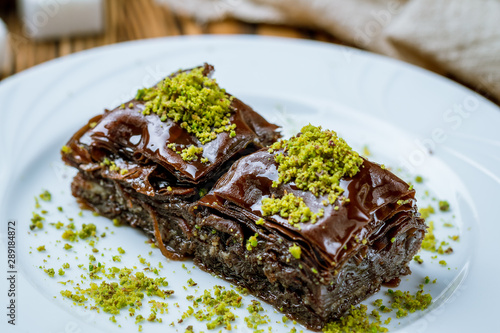 chocolate baklava with pistachios on wooden table. Turkish cuisine
