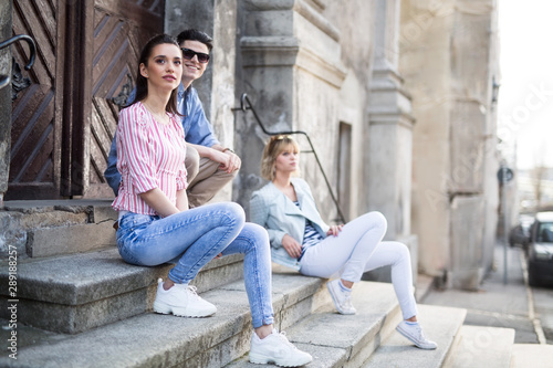 Three young adults sitting on the steps
