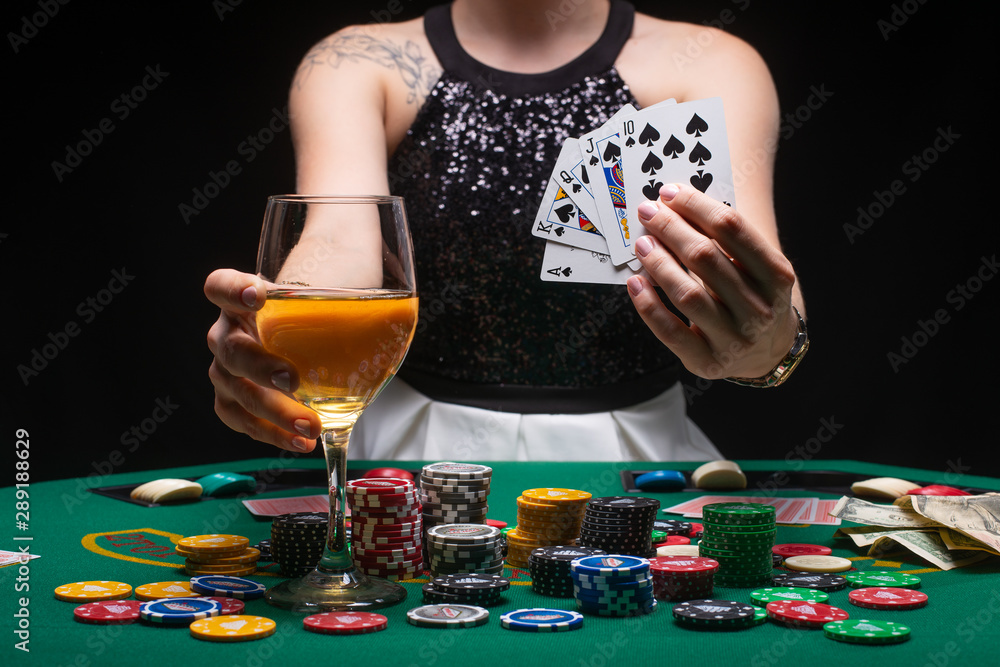 Girl poker player shows a winning combination in cards against the background of chips, money. The concept of a casino, gaming hall, winners and winnings. Nightlife of success Girl poker player shows a winning combination in cards against the background of chips, money. The concept of a casino, gaming hall, winners and winnings. Nightlife of success