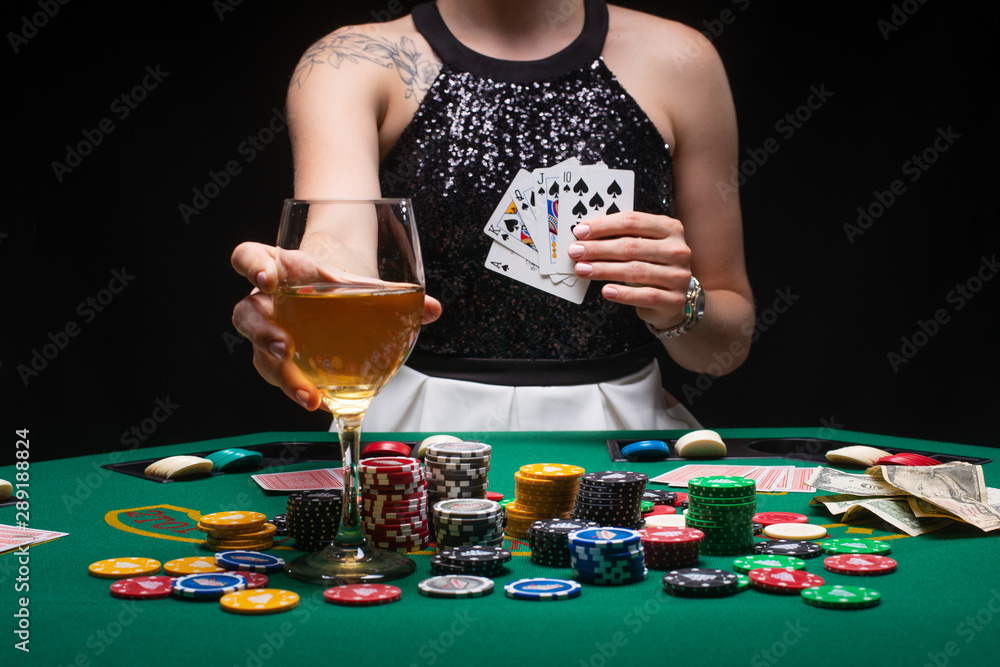 Girl poker player shows a winning combination in cards against the background of chips, money. The concept of a casino, gaming hall, winners and winnings. Nightlife of success Girl poker player shows a winning combination in cards against the background of chips, money. The concept of a casino, gaming hall, winners and winnings. Nightlife of success
