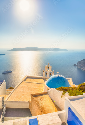 Romantic Picturesque View of Traditional Orthodox Blue Domed Church of Thira in Santorini. With Ferry on Background.