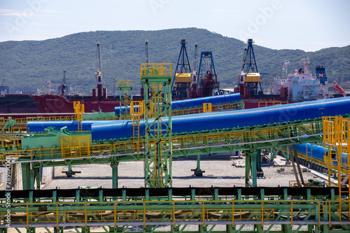 The territory of the marine coal terminal. Construction site of a coal terminal. Warehouse with building materials on the seashore. © alexhitrov