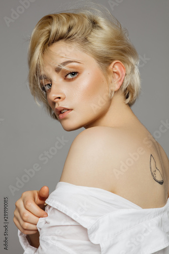 Portrait of beautiful blonde woman in white shirt and messy hair