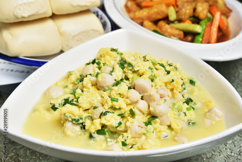 Scrambled egg with seafood and green onions in white plate 