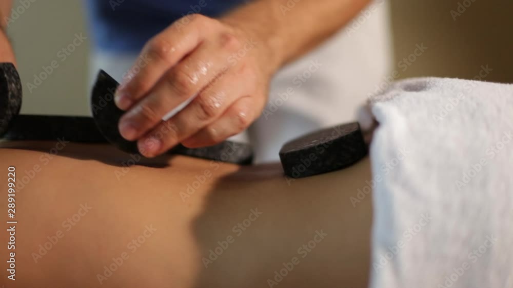 Young woman having hot stone massage in spa salon.Close-up Young woman having hot stone massage in spa salon.Close-up