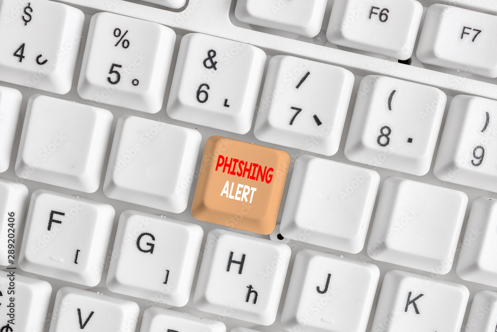 Writing note showing Phishing Alert. Business concept for aware to fraudulent attempt to obtain sensitive information White pc keyboard with note paper above the white background Writing note showing Phishing Alert. Business concept for aware to fraudulent attempt to obtain sensitive information White pc keyboard with note paper above the white background