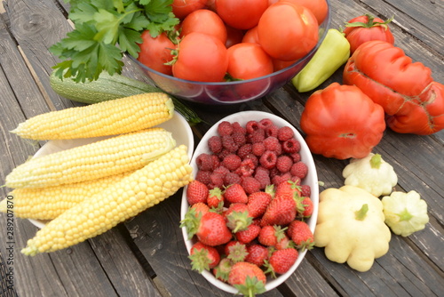 harvested vegetables. Tomatoes  corn  berries  eggplant on a wooden dark background