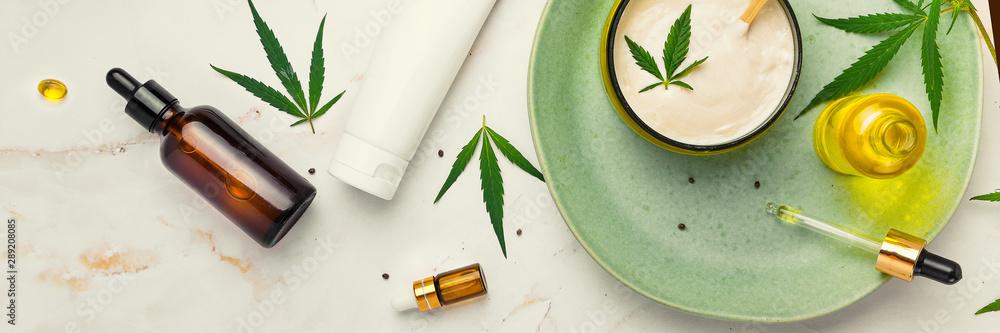 Cosmetics with cannabis oil on a turquoise plate on a light marble background. Copy space, mockup. Banner - obrazy, fototapety, plakaty 