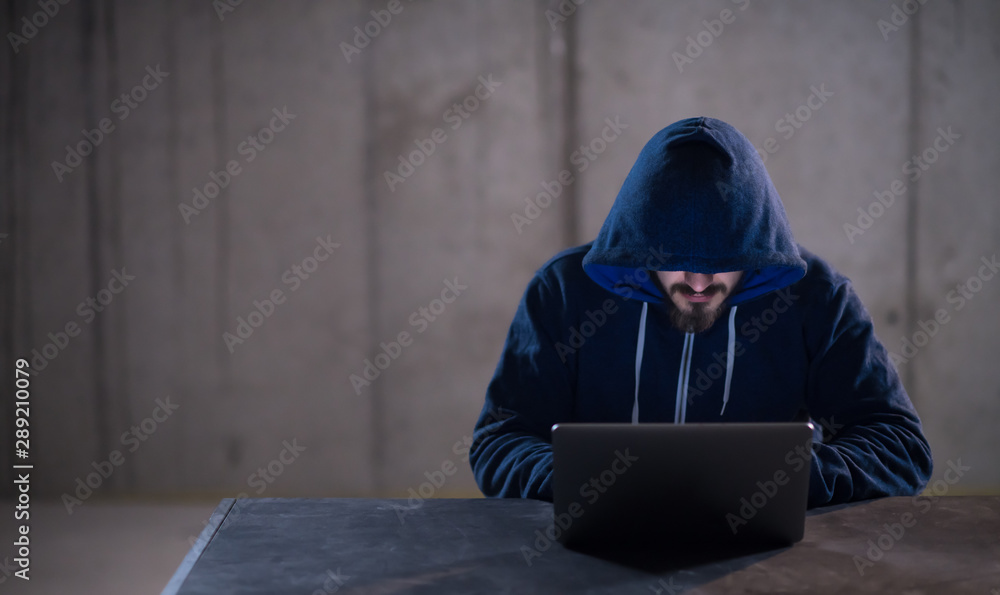 talented hacker using laptop computer while working in dark office talented hacker using laptop computer while working in dark office