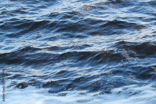 Waves of blue river water background with white foam in Florida nature