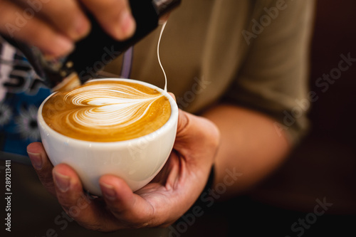 Close up barista pour milk foam made latte art. Coffee art.