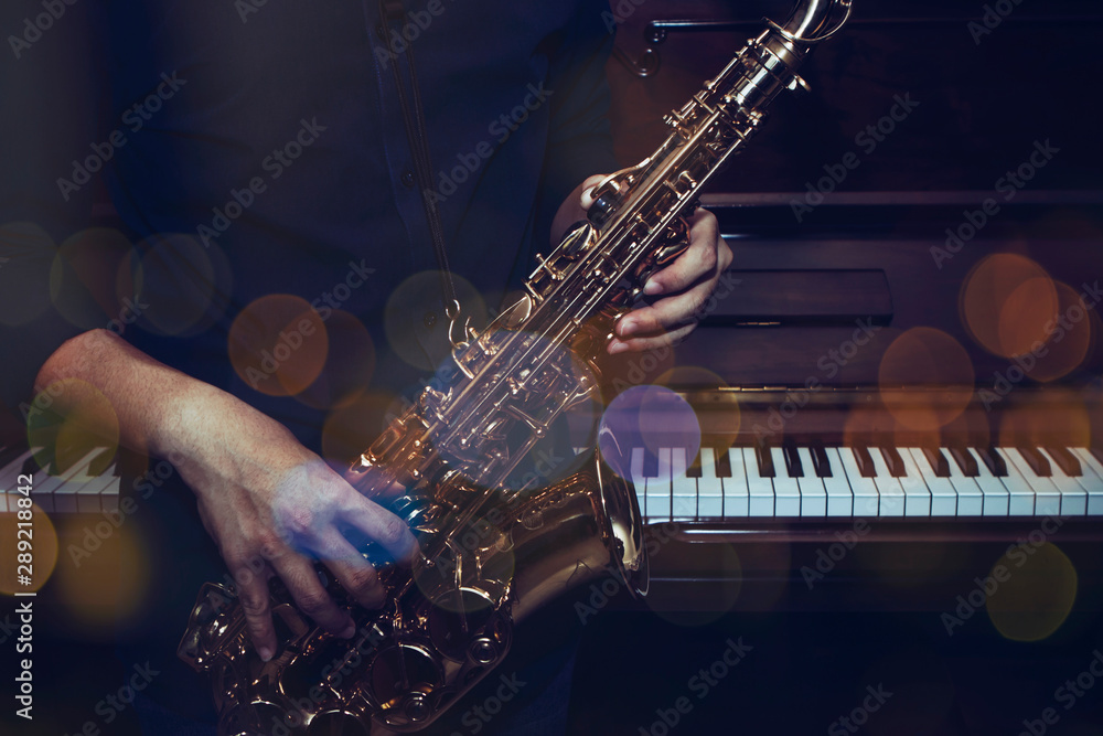 Fototapeta premium close up of saxophone player plays saxophone with music concert light and Bokeh on stage
