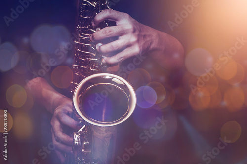 close up of saxophone player plays saxophone with music concert light and Bokeh on stage