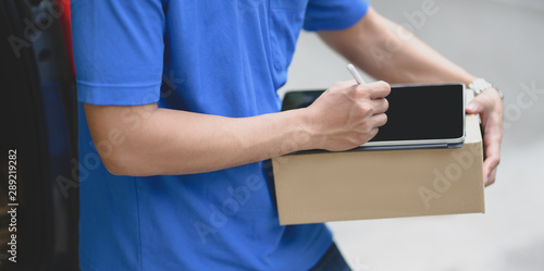 Cropped view of young delivery man preparing parcel box to customer and checking orders