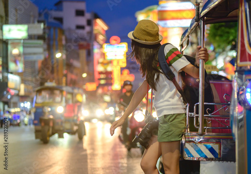 Photography woman tourist standing at street side calls motor tricycle, local transport serv