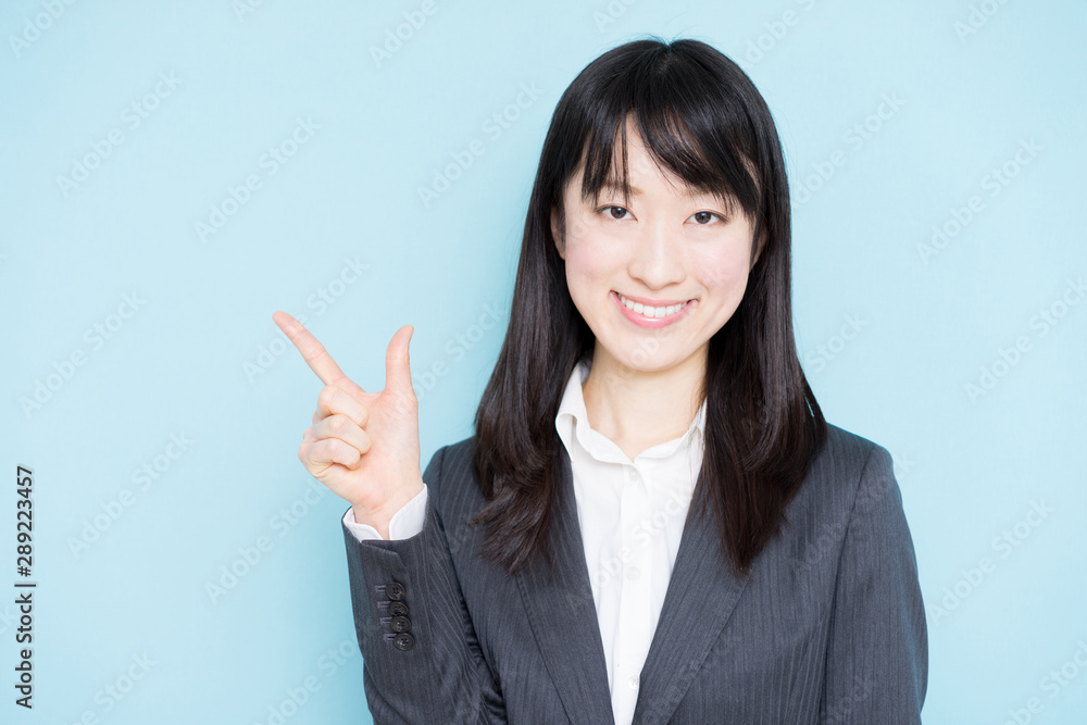 Young business woman explaining against light blue background Young business woman explaining against light blue background