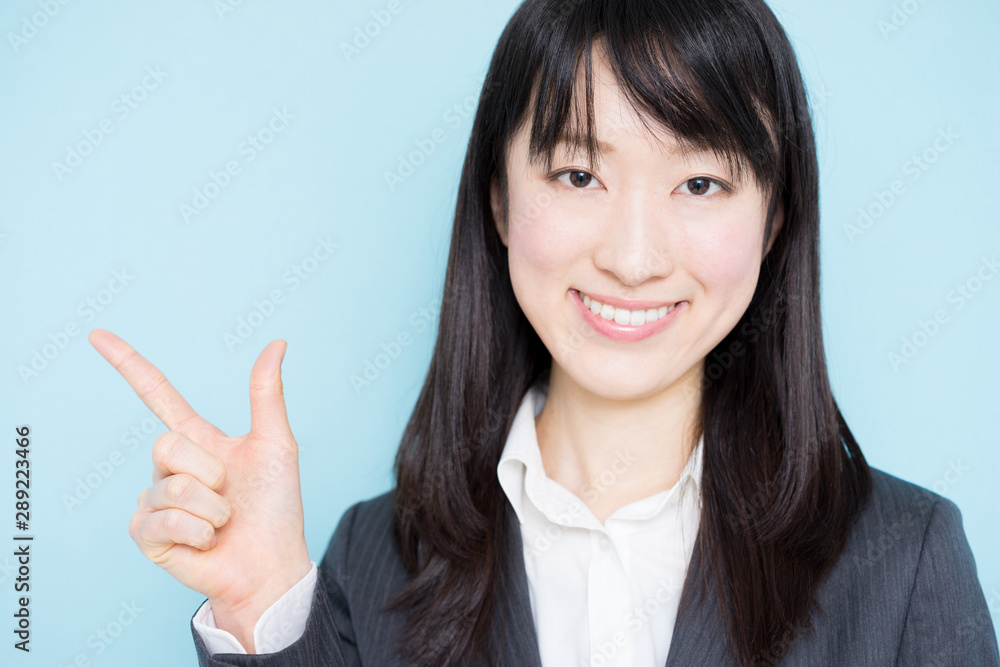 Young business woman explaining against light blue background Young business woman explaining against light blue background