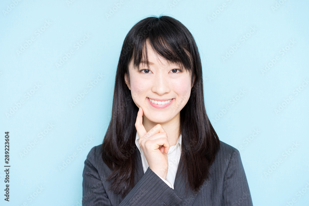 Young business woman thinking against light blue background Young business woman thinking against light blue background