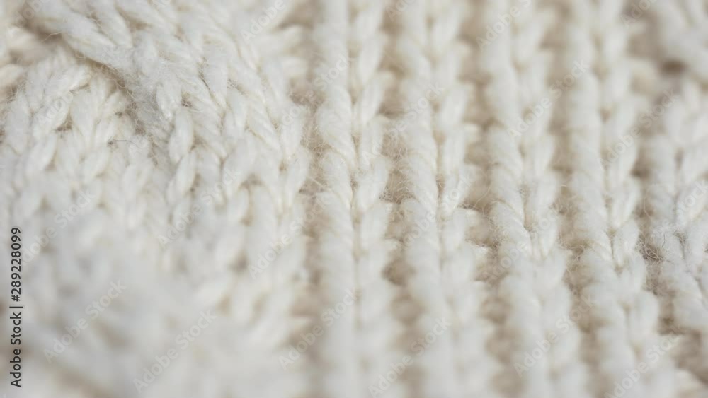 Super macro dolly shot of soft warm white woolen braided fabric to keep warm in winter. Christmas clothes. Super macro dolly shot of soft warm white woolen braided fabric to keep warm in winter. Christmas clothes.