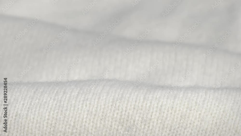 Stunning macro dolly shot of soft warm white woolen fabric to keep warm in winter. Christmas clothes or blanket. Stunning macro dolly shot of soft warm white woolen fabric to keep warm in winter. Christmas clothes or blanket.