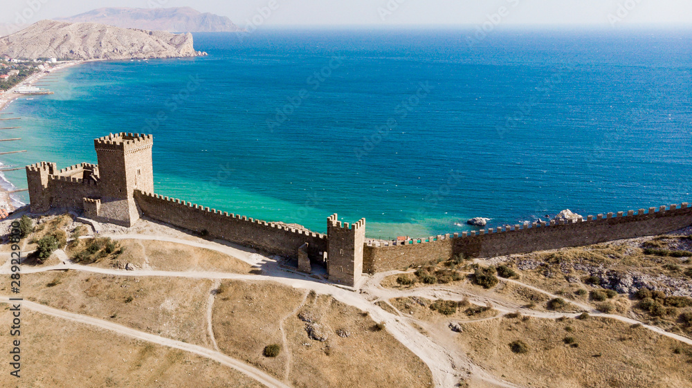 Obraz premium Architectural landmark, sight Of Crimea. Genoese fortress in Sudak. Aerial view of the ruins of an ancient castle or fortress on a mountain by the sea. Beautiful summer tourist landscape