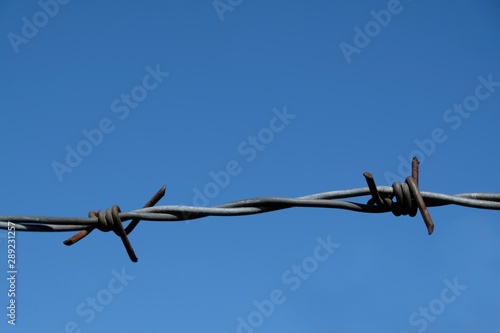 Single barbed wire against a blue sky.