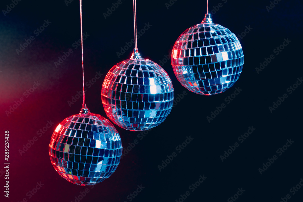 Obraz premium Sparkling disco balls hanging in the air against black background