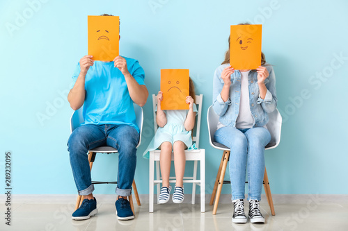 Young family hiding faces b...