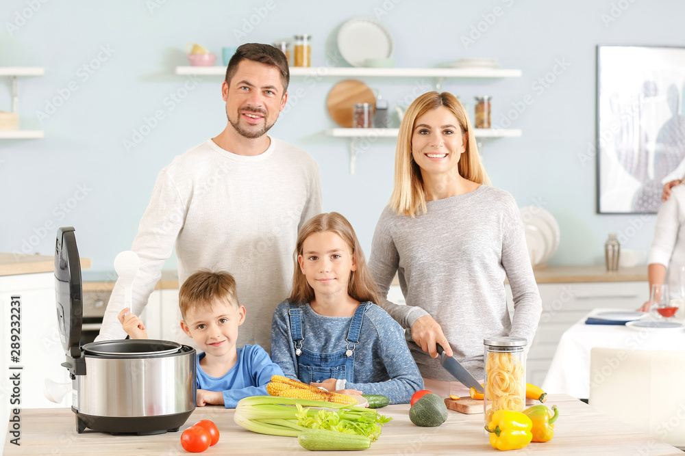 Happy family with modern multi cooker in kitchen Happy family with modern multi cooker in kitchen