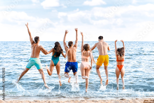 Happy friends on sea beach at resort