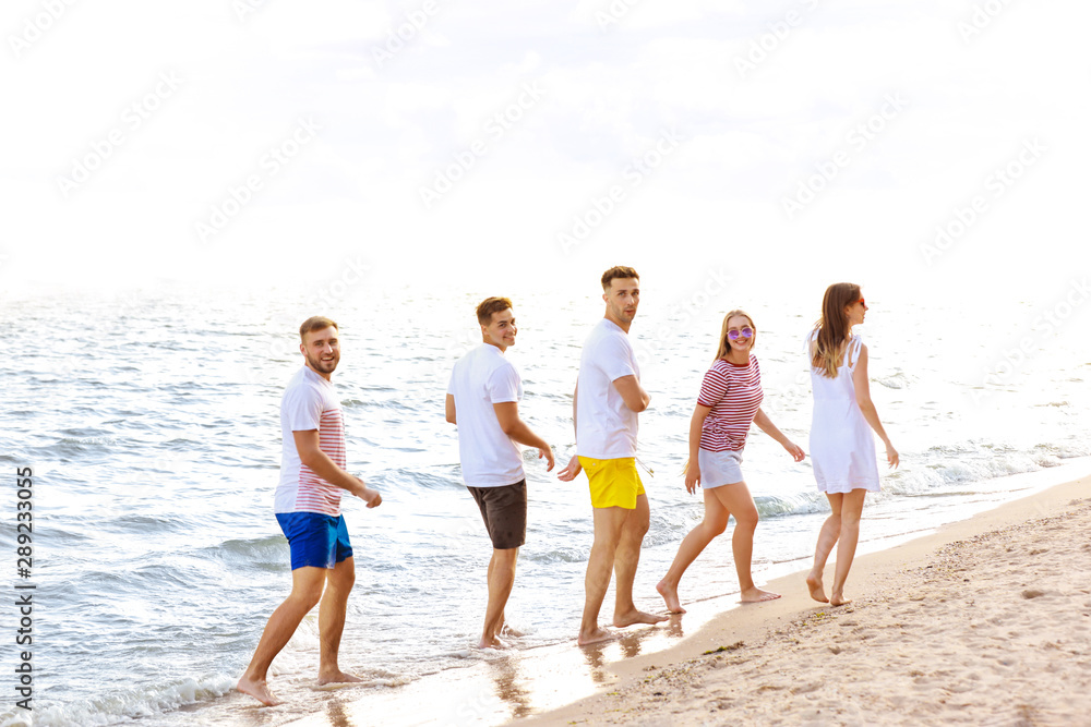 Happy friends on sea beach at resort